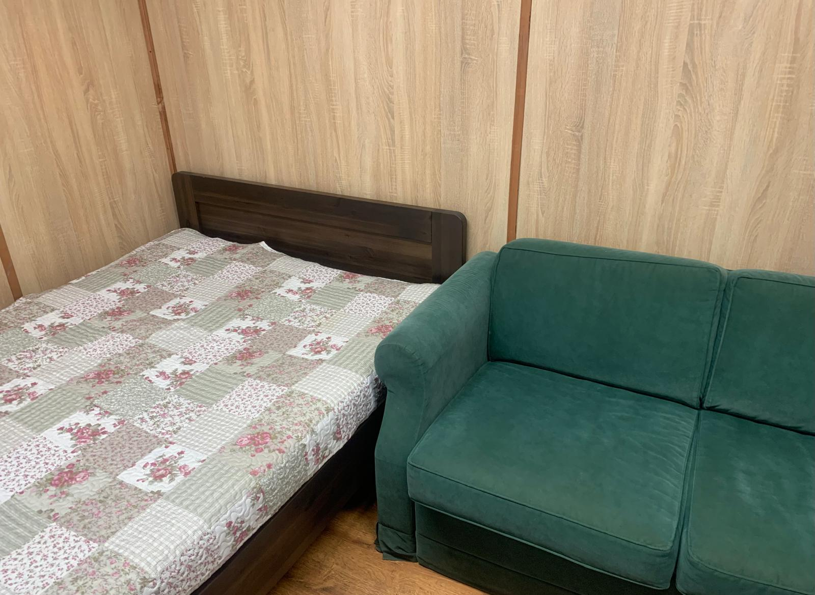 Двуспальная кровать и диван в номере